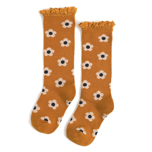 Pair of mustard yellow socks with white flower patterns on a white background